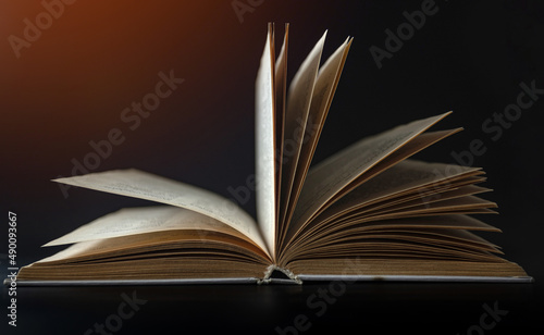 Open book, hardcover books on a dark background.