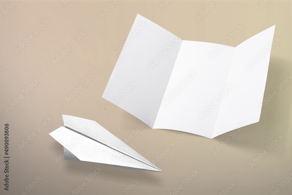 A white paper plane and blank paper on background. A white paper plane and blank paper on background.