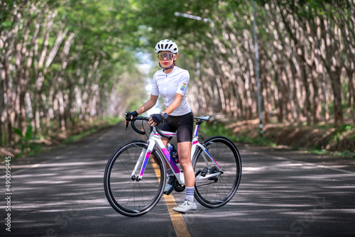 happy woman cycling athlete prepare for ride bicycle on street, road, with high speed for exercise hobby and competition in professional tour