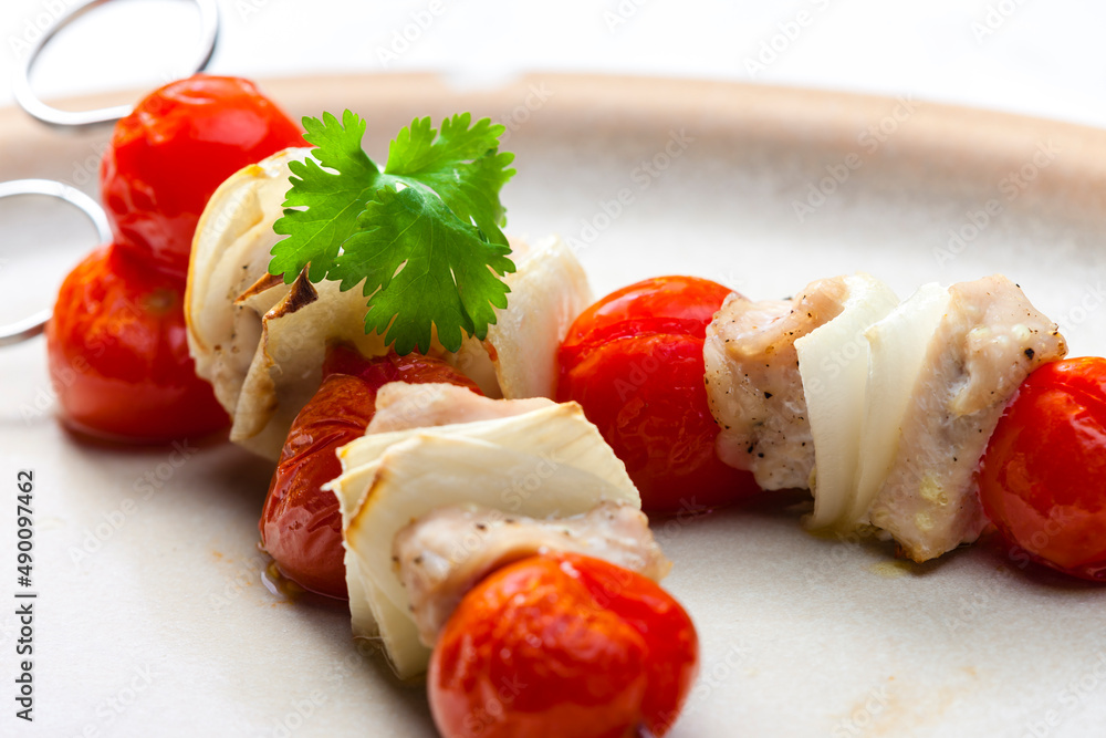 skewers with chicken meat , tomatoes and onion