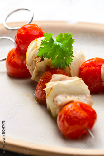 skewers with chicken meat , tomatoes and onion