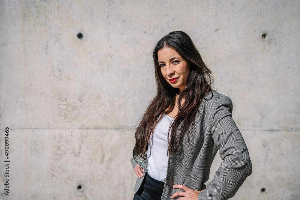 Well dressed ethnic lady standing on street with hands on waist Well dressed ethnic lady standing on street with hands on waist