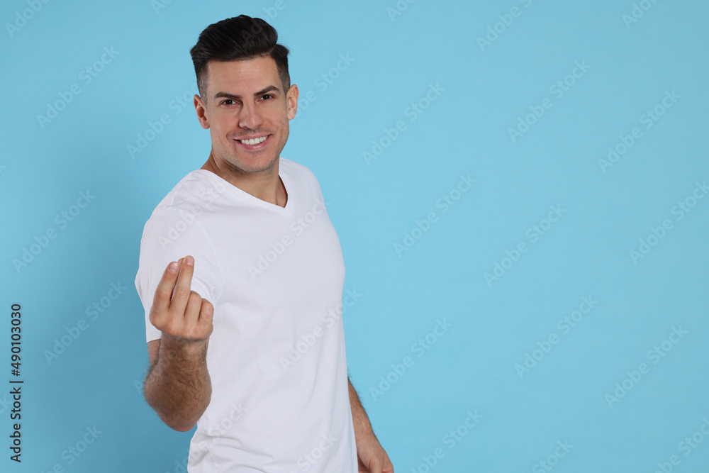 Handsome man snapping fingers on light blue background. Space for text Handsome man snapping fingers on light blue background. Space for text