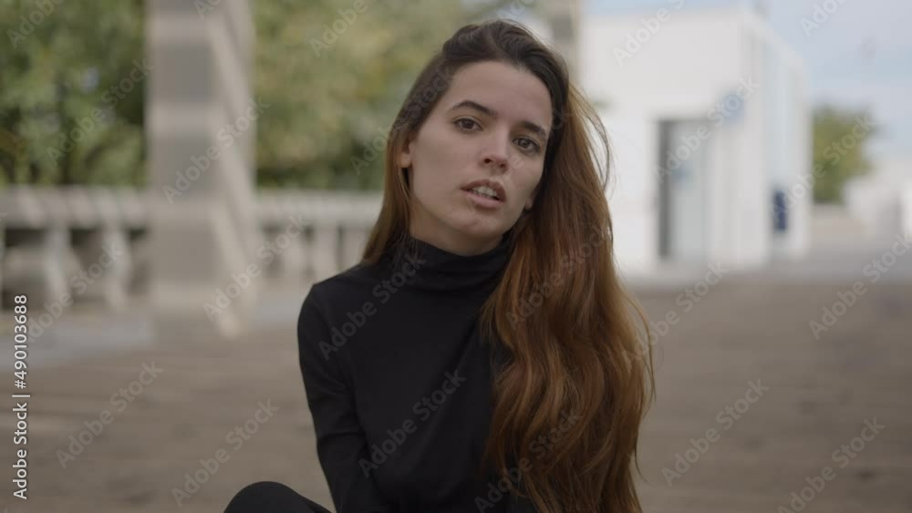 Young woman outdoors moves head while looking into camera, close slomo Young woman outdoors moves head while looking into camera, close slomo