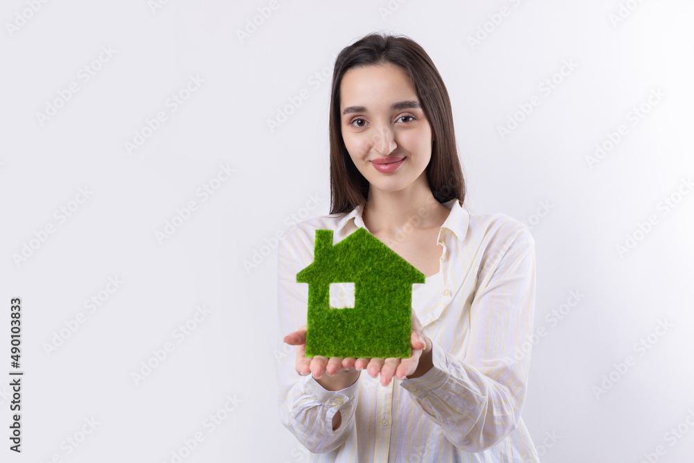 A young girl realtor holds a model of a green house in her hands. Sale of ecological real estate. A young girl realtor holds a model of a green house in her hands. Sale of ecological real estate.