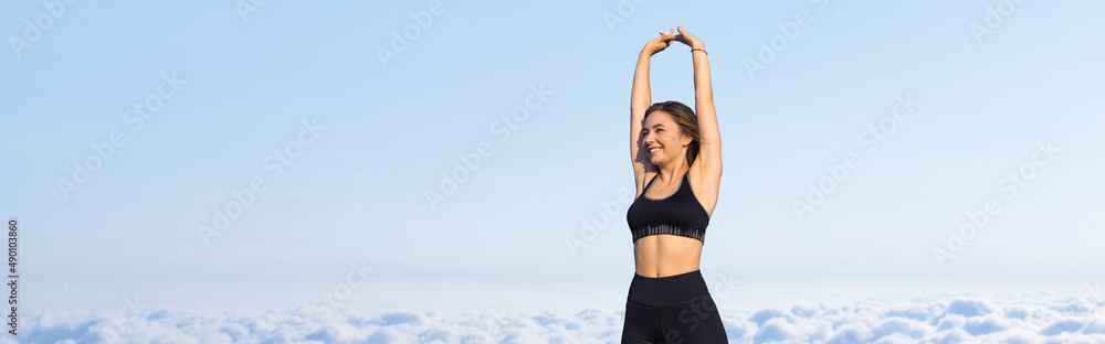 A young slim athletic girl in sportswear performs a set of exercises. Fitness and healthy lifestyle against the background of clouds sky. A young slim athletic girl in sportswear performs a set of exercises. Fitness and healthy lifestyle against the background of clouds sky.