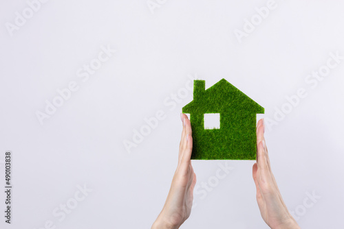 Female hands hold a model of a green house close-up. Sale of ecological real estate of the future.