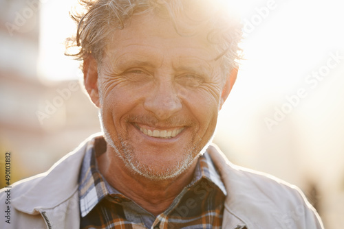 Hes got a sunny outlook on life. Portrait of a friendly-looking middle aged man outside. photo