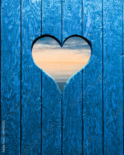 Herz in einer Holzwand mit Blick zum Meer