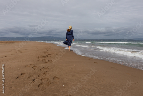 Woman walking along the beach in the Ebro Delta, Catalonia (Spain)