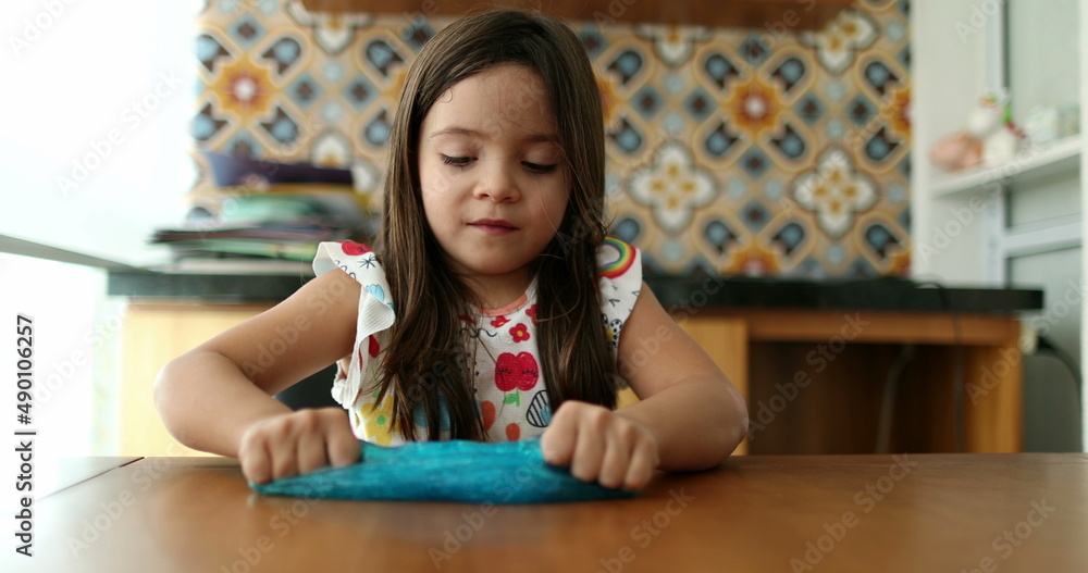Child hands playing with slime goo. Little girl close-up hand and fingers with sticky elastic plasticine Child hands playing with slime goo. Little girl close-up hand and fingers with sticky elastic plasticine