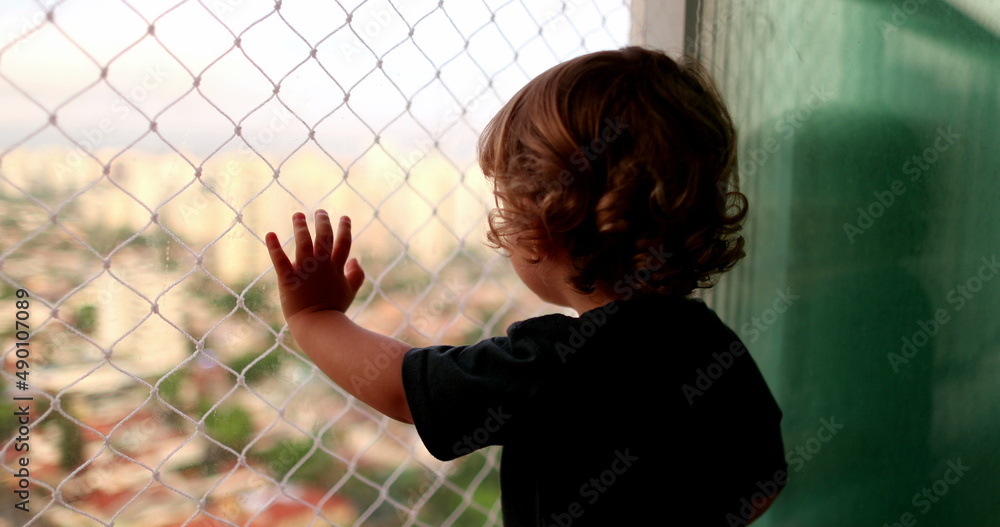 © Marco - Baby child hand leaning on window balcony with safety net