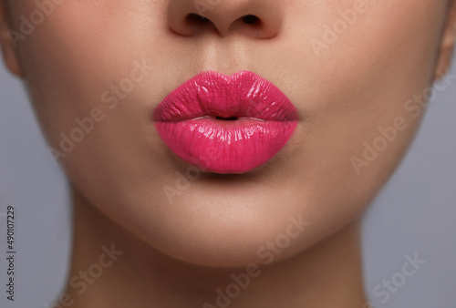 Closeup view of beautiful woman puckering lips for kiss.on grey background