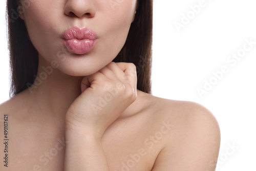 Closeup view of beautiful woman puckering lips for kiss on white background