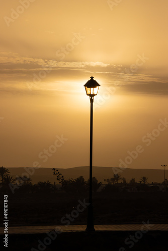 setting sun illuminating old lamp post