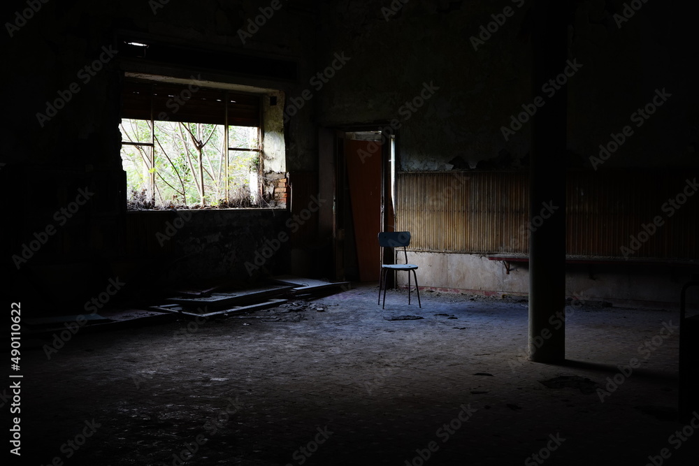 Chair in the middle of the room in abandoned building in ruins Chair in the middle of the room in abandoned building in ruins