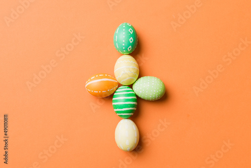 holiday preparation Multi colors Easter eggs on colored background, cross show the religious and secular side of Easter. Pastel color Easter eggs. holiday concept with copy space