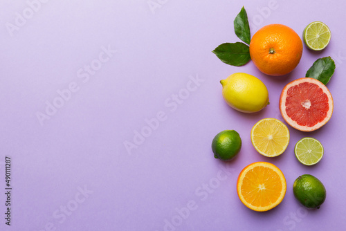 Fruit background. Colorful fresh fruits on colored table. Orange, lemon, grapefruit Space for text healthy concept. Flat lay, top view, copy space © sosiukin