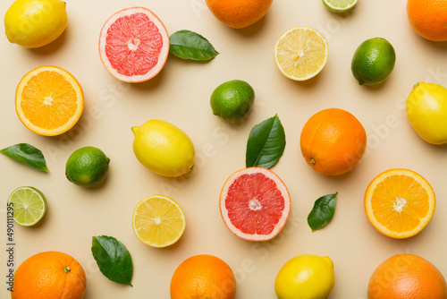 Flat lay of citrus fruits like lime  orange and lemon with lemon tree leaves on light colored background. Space for text healthy concept. Top view