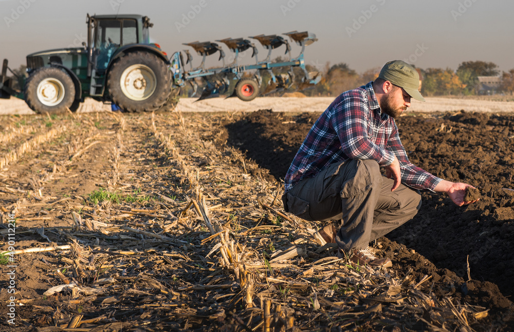 Obraz premium Male Farmer Examines Soil Quality