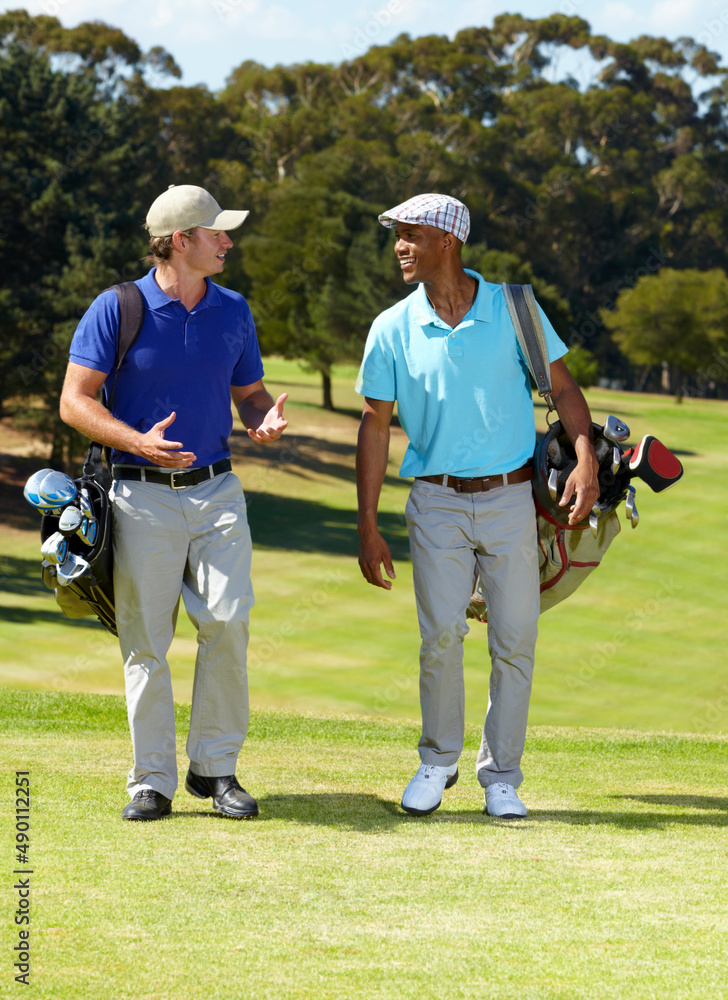 Obraz premium Discussing the handicaps. Shot of two friends talkin on their way to the tee-off.