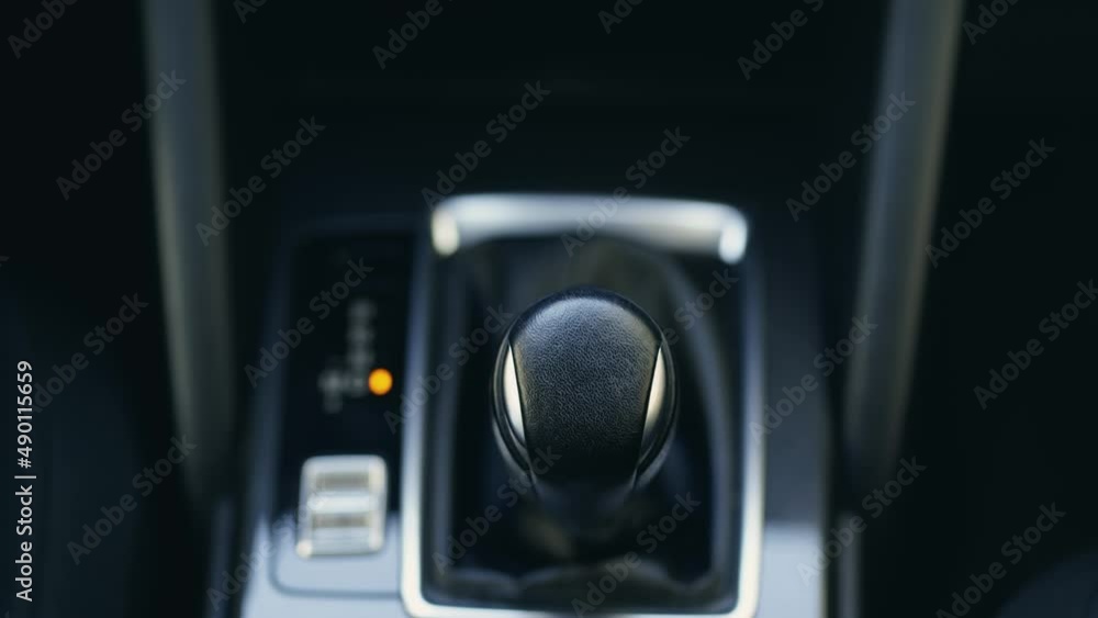Female hand using a car automatic gear. Woman driving concept Female hand using a car automatic gear. Woman driving concept