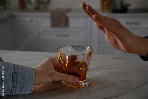 Man refusing to drink whiskey at home, closeup. Alcohol addiction treatment