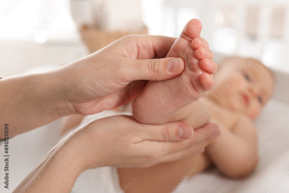 Mother massaging her cute baby with oil at home, closeup Mother massaging her cute baby with oil at home, closeup