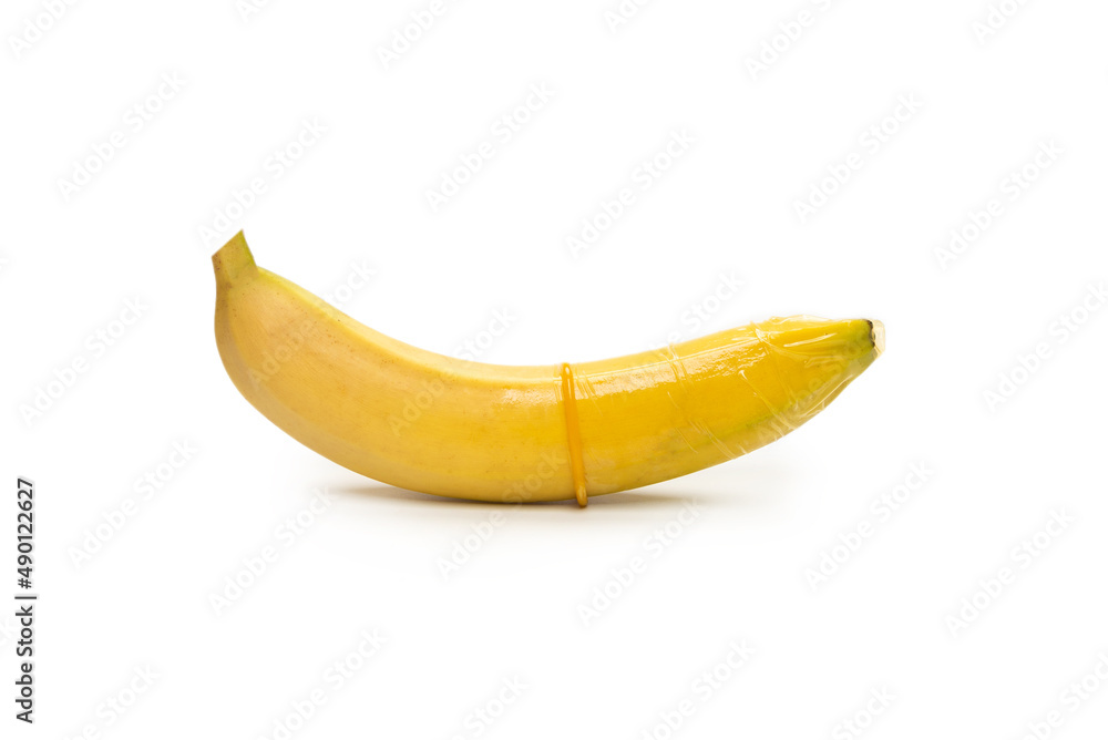 A banana with a condom on it isolated on white background.