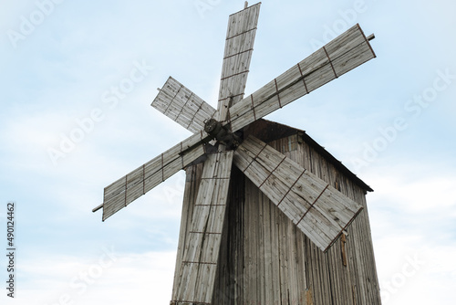 Old wooden windmill for grinding grain into flour, against the background of a clear, blue sky, copy space