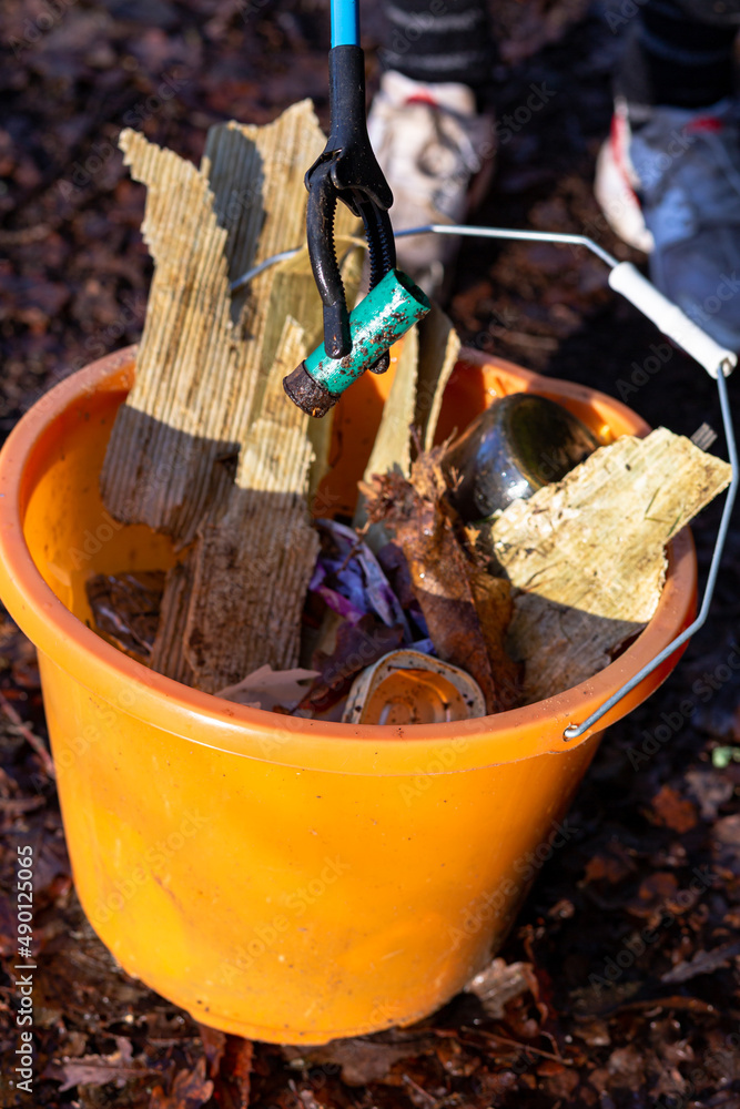 A close up of a bucket full of litter that has been collected from a litter pick in the countryside. Litter pick, rubbish, environmental concept A close up of a bucket full of litter that has been collected from a litter pick in the countryside. Litter pick, rubbish, environmental concept