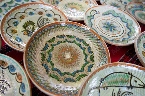 Traditional ceramic hand painted plates exposed on a table in Horezu, Valcea, Romania.