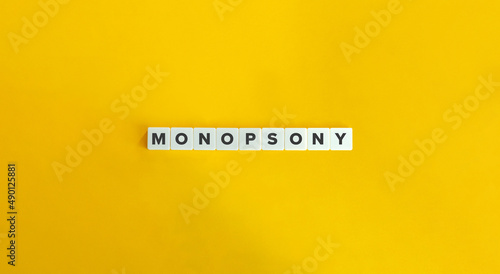 Monopsony Word on Letter Tiles on Yellow Background. Minimal Aesthetics. photo