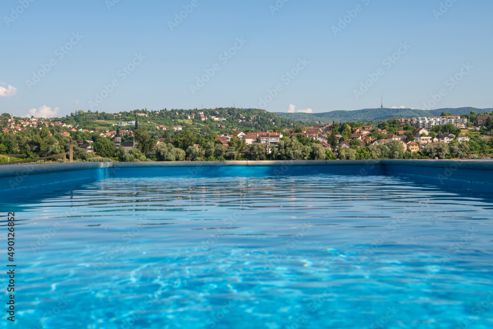 Empty Swimming pool with beautiful city view of Novi Sad, Serbia. Luxury summer vacation concept.