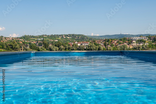 Empty Swimming pool with beautiful city view of Novi Sad, Serbia. Luxury summer vacation concept.