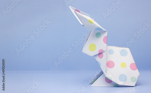 Easter paper origami bunny on blue background