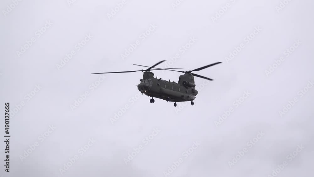 close up of an RAF Chinook tandem-rotor CH-47 helicopter descending on final approach to land in woodland, cloudy blue grey sky on a military battle exercise, Wilts UK close up of an RAF Chinook tandem-rotor CH-47 helicopter descending on final approach to land in woodland, cloudy blue grey sky on a military battle exercise, Wilts UK