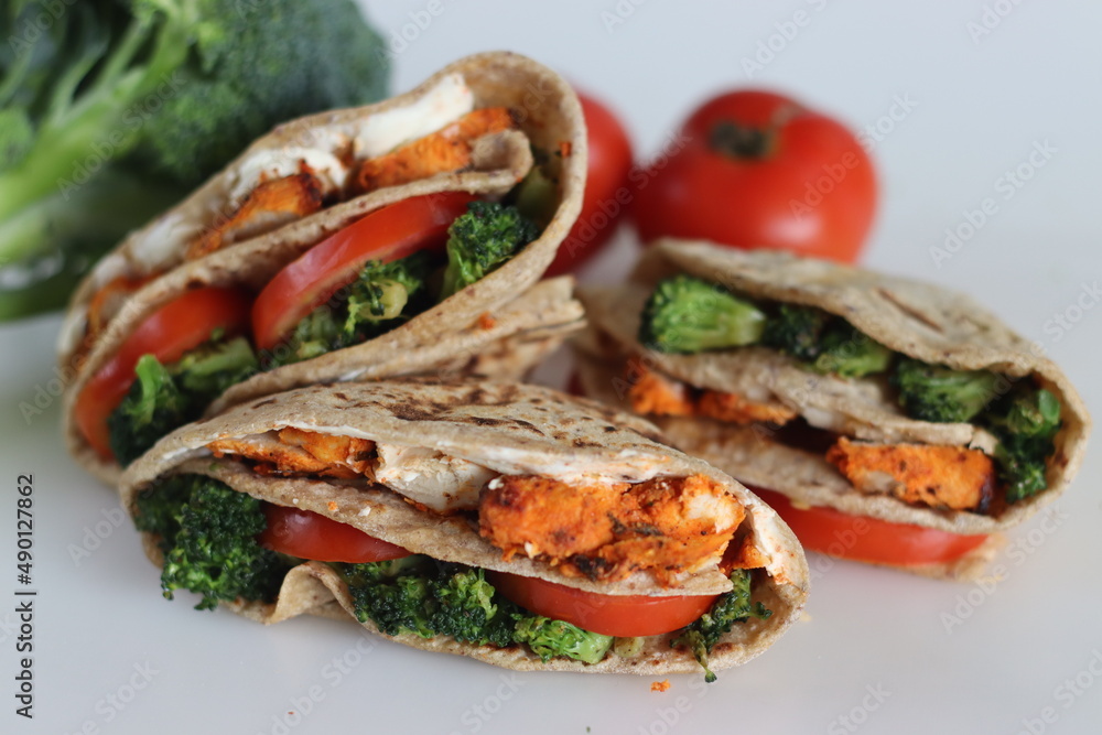 Chicken wraps. Grilled chicken, sauteed broccoli and fresh tomato slices wrapped in a whole wheat flat bread smeared with cream cheese