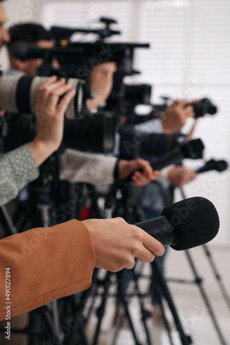 Foto Group of journalists with cameras waiting for official person indoors, closeup