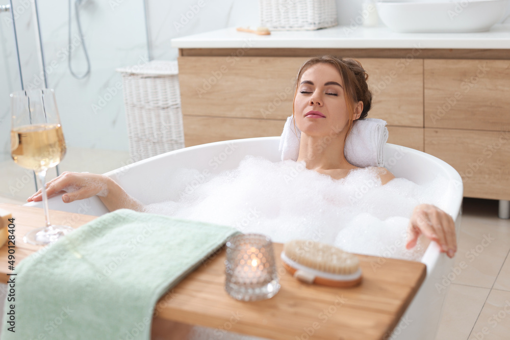 Naklejka premium Beautiful woman enjoying bubble bath at home