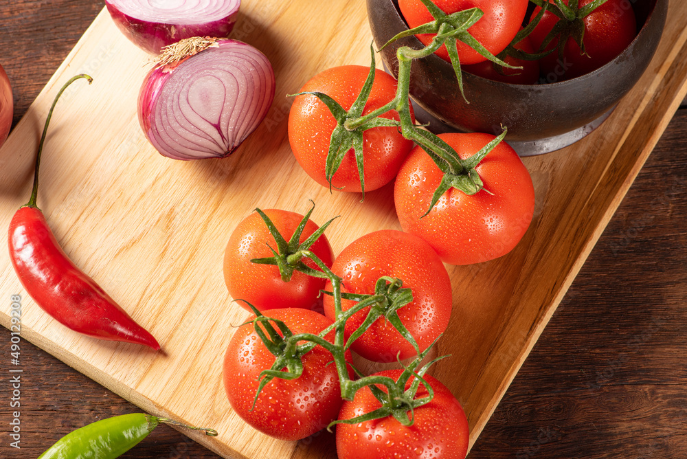Table with red and yellow peppers, peppers, onions and garlic and tomatoes, over rustic wood, black background, top view. Table with red and yellow peppers, peppers, onions and garlic and tomatoes, over rustic wood, black background, top view.