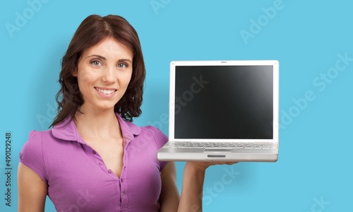 Portrait of attractive cheerful skilled girl using laptop on a background