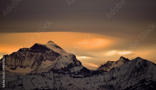 Snow mountain with orange colored sky