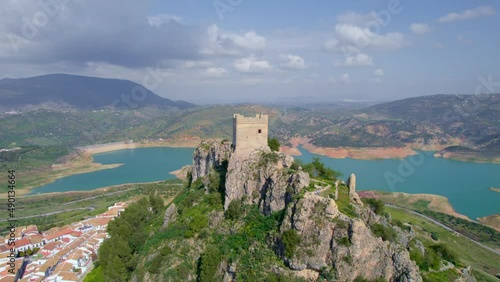 flying around an ancient fortress in medieval Andalusian white village near a blue lake, Iberian landmark and Spanish tourist destination, the village of Zahara de la Sierra