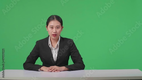 Live News Studio With Professional Asian Female Anchor Reporting On The Events Of The Day On The Green Screen
 photo