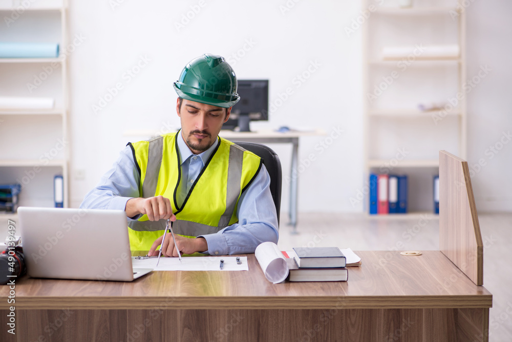 Young male architect working in the office Young male architect working in the office