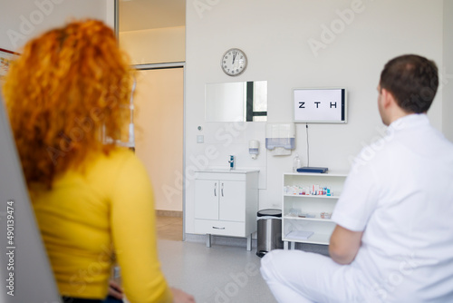 An ophthalmologist conducting an eyesight test with a female patient photo