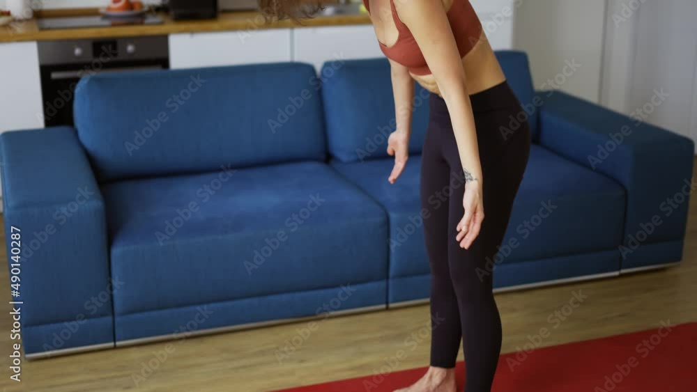 A slender woman performs asana raising up from the floor, connecting hands in namaste A slender woman performs asana raising up from the floor, connecting hands in namaste