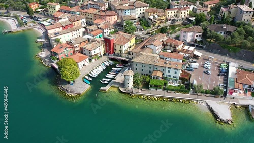 Aerial video top view of waterfront with port (with little boats) and restaurants of  Cassone di Malcesine, the old town, on the eastern shore of Lake Garda , Italy - K4 movie photo