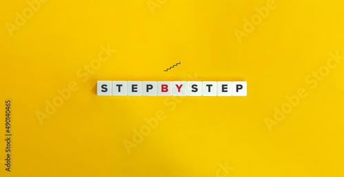 Step by Step Phrase on Letter Tiles on Yellow Background. Minimal Aesthetics. photo